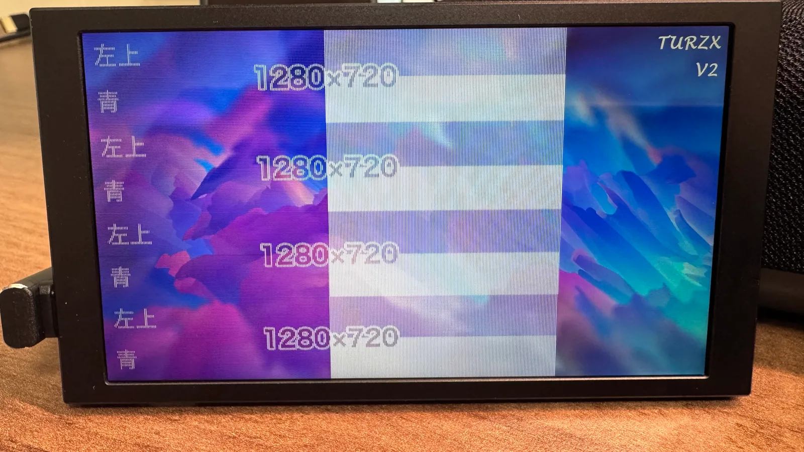 5.2 インチに既定の紫と青の背景が透けて見え、右上に「TURZX V2」。「左上」「青」「1280×720」の文字と白い面だけが、縦に 4 回繰り返して描かれている